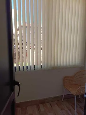 a window with white blinds in a room with a chair at APARTEMENT VIVA in Sandanski
