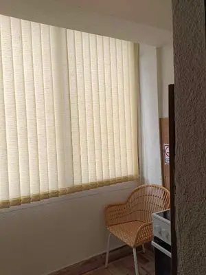 a window with blinds in a room with a chair at APARTEMENT VIVA in Sandanski