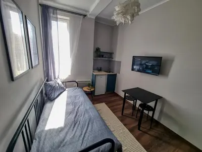 a small bedroom with a bed and a table at Cozy Studio in Center of Sofia in Sofia