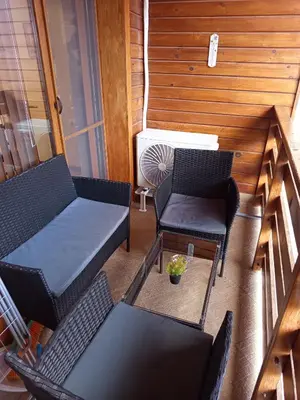 a balcony with chairs and a table and a heater at St Ivan Rilski Free SPA Luxury Apartment Bansko in Bansko