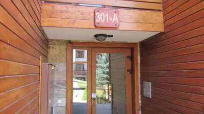 a door to a house with a sign above it at St Ivan Rilski Free SPA Luxury Apartment Bansko in Bansko