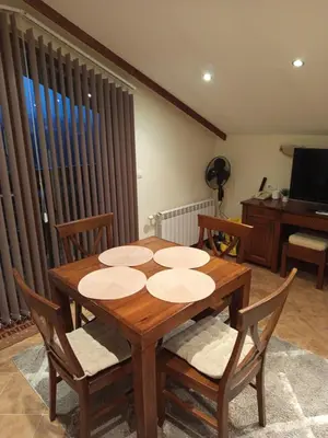 a dining room with a wooden table and chairs at St Ivan Rilski Free SPA Luxury Apartment Bansko in Bansko