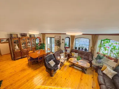 a living room with leather furniture and a wooden floor at Villa Janet in Dolna Banya