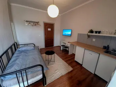 a bedroom with a bed and a kitchen with a counter at Welcoming Studio in Sofia Center in Sofia