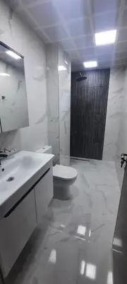 a white bathroom with a toilet and a sink at Zora in Blagoevgrad