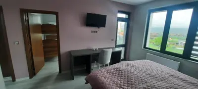 a bedroom with a desk and a bed and a television at Zora in Blagoevgrad