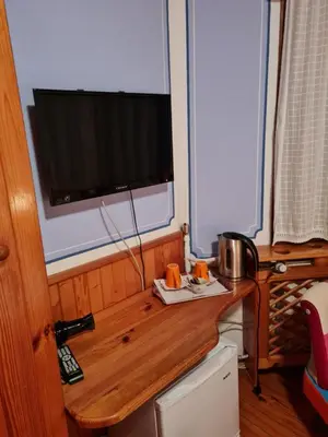 a kitchen with a wooden table with a tv on top at Астра къща за гости in Koprivshtitsa