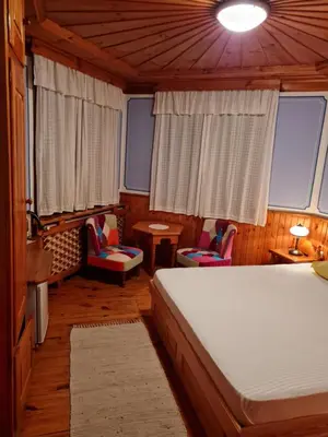 a bedroom with a bed and two chairs and a table at Астра къща за гости in Koprivshtitsa