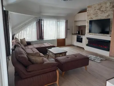 a living room with a couch and a table at ЕЛЕГАНС къща за гости in Dospat