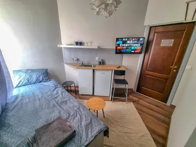 a bedroom with a bed and a sink and a desk at Inviting Studio in Sofia Center in Sofia