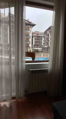 a room with a window with a view of a building at Lovely private apartment in Belelvedre in Bansko