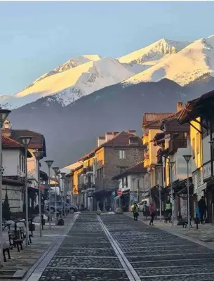 a street in a town with a mountain in the background at Lovely private apartment in Belelvedre in Bansko