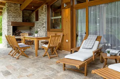 a patio with a table and chairs and a fireplace at Boutique Holiday Pirin Golf in Razlog