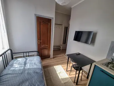 a small room with a bed and a table and a television at Sunny Studio in Sofia Center in Sofia