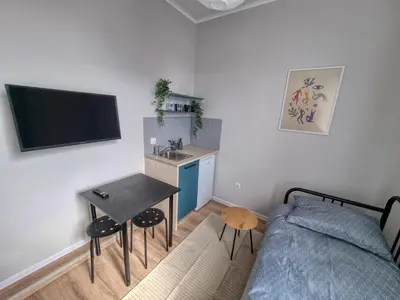 a bedroom with a bed and a sink and a table at Sunny Studio in Sofia Center in Sofia