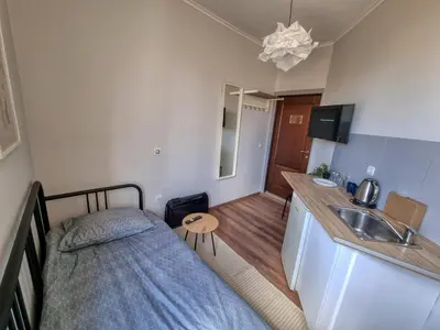 a bedroom with a bed and a sink and a kitchen at Relaxing Studio in Sofia Center in Sofia