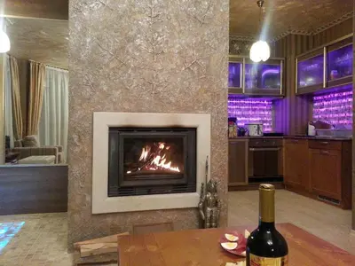 a living room with a fireplace and a bottle of wine at Harriet Hill Designer Bansko in Bansko