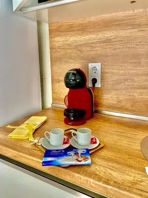 a coffee maker and two cups on a counter at M&M Center Apartment with free parking in Plovdiv
