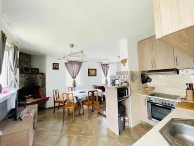a kitchen and dining room with a table and chairs at Къща за гости Замък Никола in Shtarkelovo Gnezdo