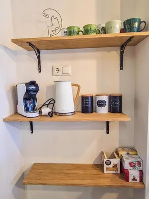 a coffee maker and coffee cups on wooden shelves at Cozy 2BD Apartment in Bansko by Flat Mаnager in Bansko