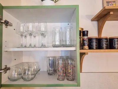 a bunch of glasses sitting on a shelf at Cozy 2BD Apartment in Bansko by Flat Mаnager in Bansko
