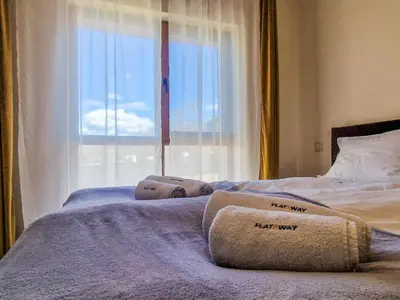 a bed with two towels on it with a window at Cozy 2BD Apartment in Bansko by Flat Mаnager in Bansko