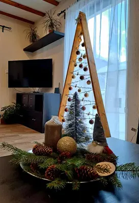 a christmas tree on a table in a living room at Тиловите къщи in Ribarica