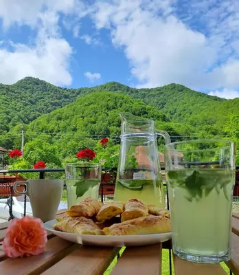 a plate of pastries sitting on a table with drinks at Тиловите къщи in Ribarica