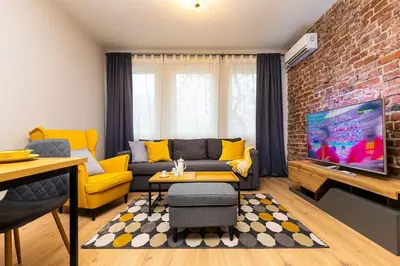 a living room with a couch and a brick wall at Private House in the Center of Plovdiv in Plovdiv