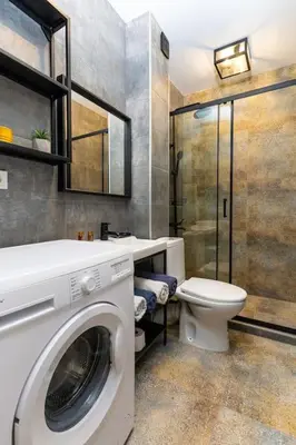 a bathroom with a washing machine and a toilet at Private House in the Center of Plovdiv in Plovdiv