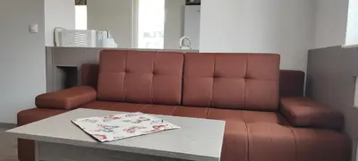 a brown couch in a living room with a table at Kiki Home in Blagoevgrad