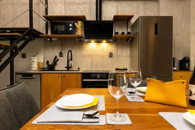a kitchen with a wooden table with two wine glasses at Industrial-style 2BD Loft with Parking Spot by Flat Mаnager in Plovdiv