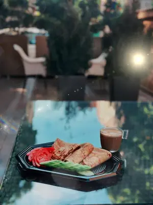 a plate of food on a glass table with a drink at Hidden Bank: Pearls in Plovdiv