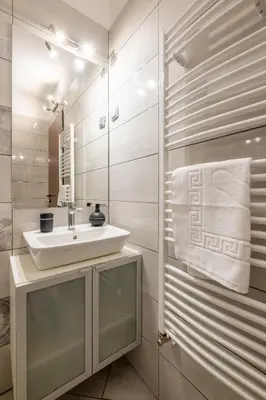 a bathroom with a sink and a mirror at Modern Apartment 3 with Parking next to Bulgaria Mall in Sofia