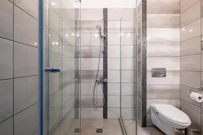 a bathroom with a glass shower with a toilet at Modern Apartment 3 with Parking next to Bulgaria Mall in Sofia