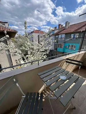 a balcony with a picnic table and a flowering tree at Rio Sunny 2BDR Apt near NDK - Metro - non-stop paid public Parking in Sofia