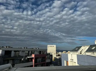 a view of a cloudy sky over some buildings at Little Jack With Terrace in Sofia
