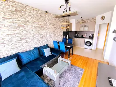 a living room with a blue couch and a brick wall at VIP Apartment Belvedere Club in Bansko
