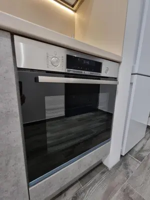 a microwave oven in a kitchen next to a wall at Apartment's Ortakchiev in Sofia