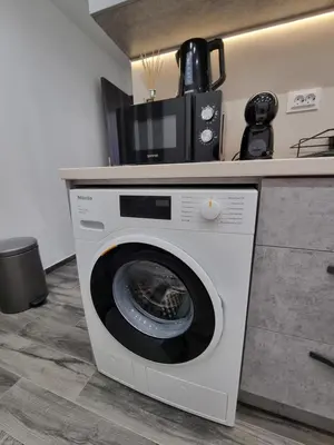 a washing machine in a kitchen next to a counter at Apartment's Ortakchiev in Sofia