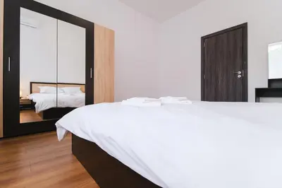 a bedroom with a large white bed and a mirror at Apartment in the city center in Plovdiv