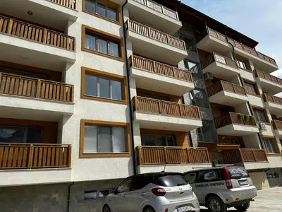 two cars parked in front of a building at Апартамент НИА in Velingrad